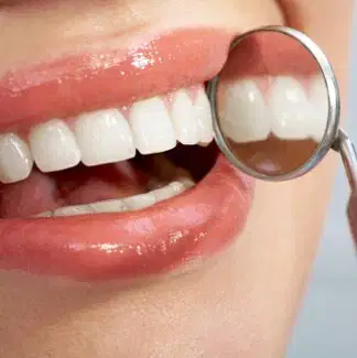 Dental Examination Close-up of teeth being examined with a dental mirror
